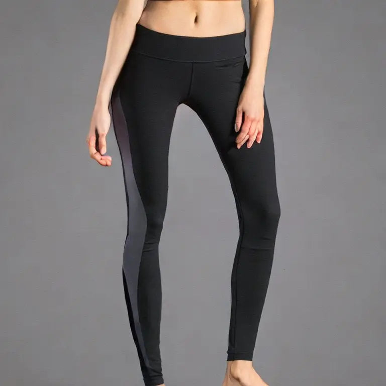 Woman wearing black yoga leggings with dark gray side stripe panels